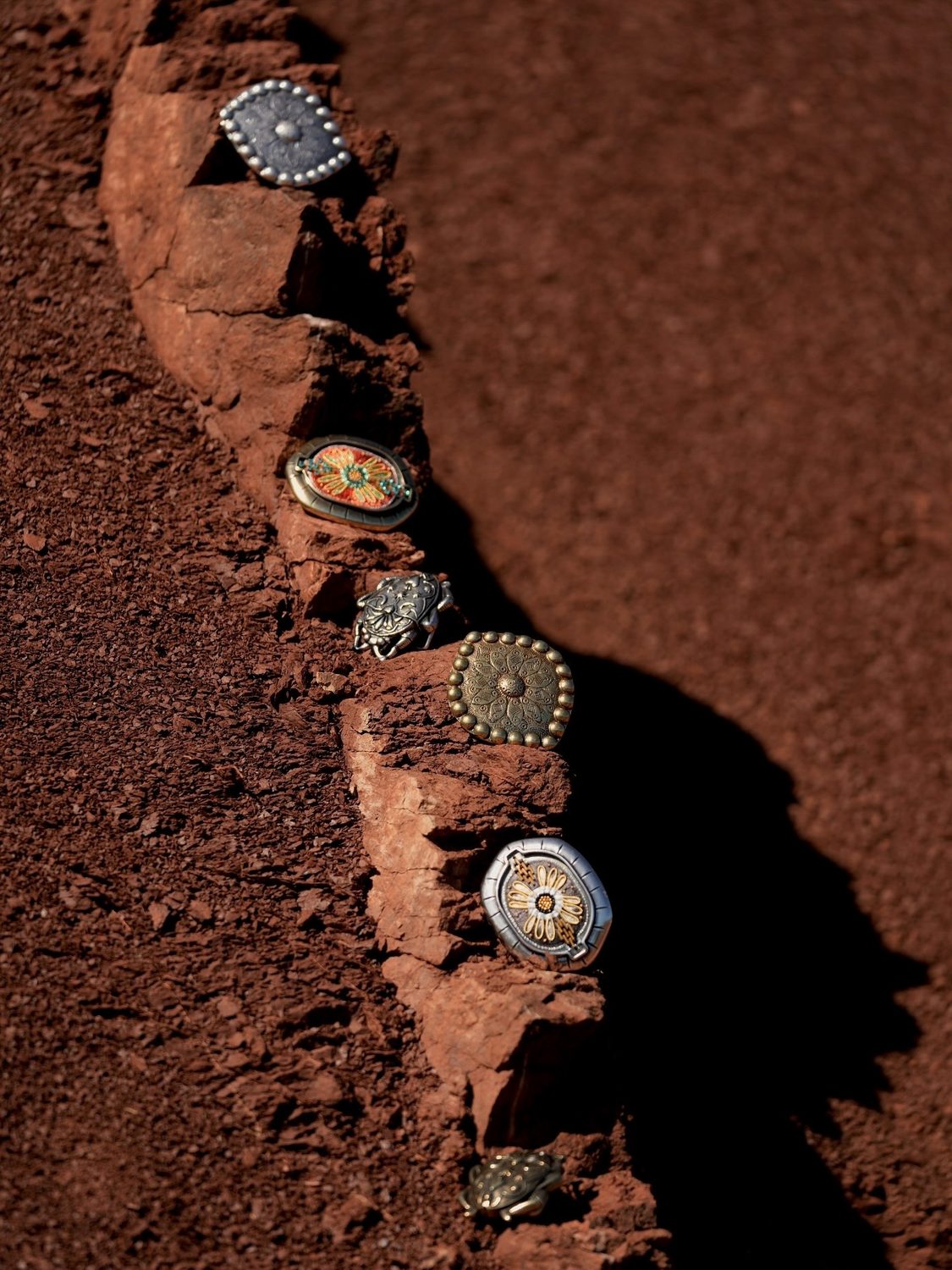 Boucles bijoux Yolète posées sur la roche rouge du canyon